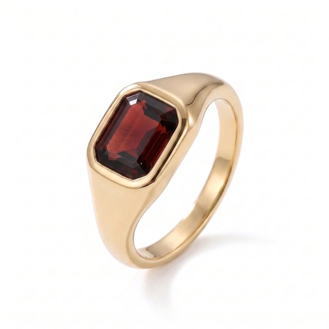 A modern interpretation of the classic signet ring, this elegant design showcases a rich garnet in a sleek bezel setting....
