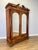 An impressive Antique French wardrobe in Walnut, featuring two tall mirrored doors, decorative inlaid detailing, turned...