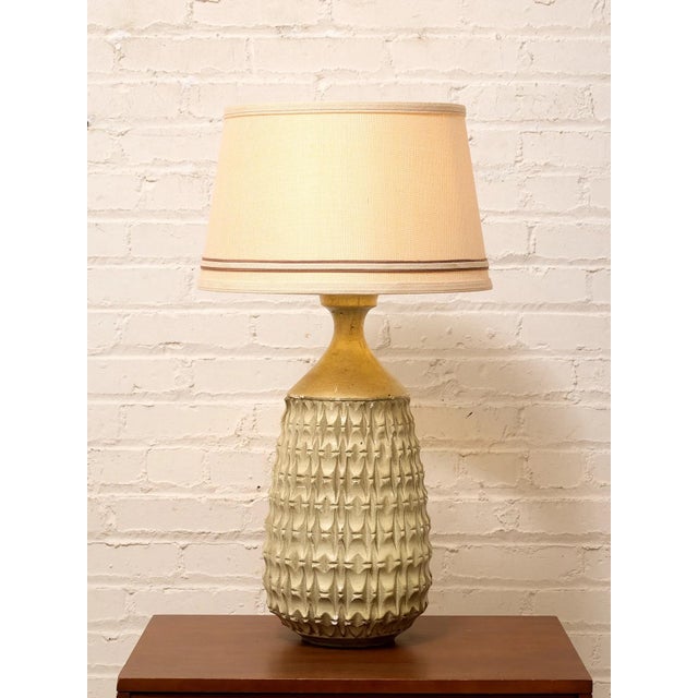 A striking vintage table lamp featuring a sculptural ceramic body covered in a deeply dimensional geometric relief. The...