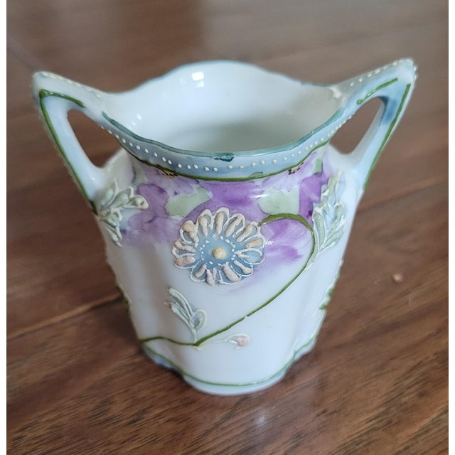 This art deco style Japanese miniature floral vase has moriage decoration with light blue and purple flowers.