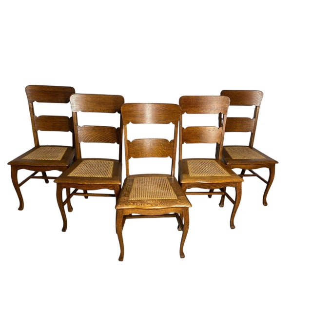 Beautiful set of 5 solid oak ladder-back chairs with caned seats and elegant cabriole legs. Sturdy, comfortable, and full...