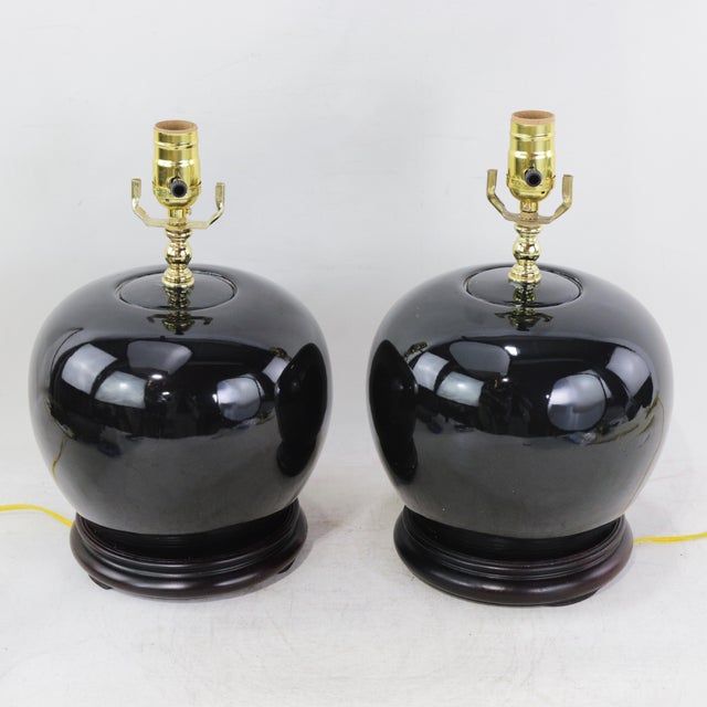 This exceptional pair of table lamps features a striking monochrome aesthetic, crafted from high-quality porcelain with a...