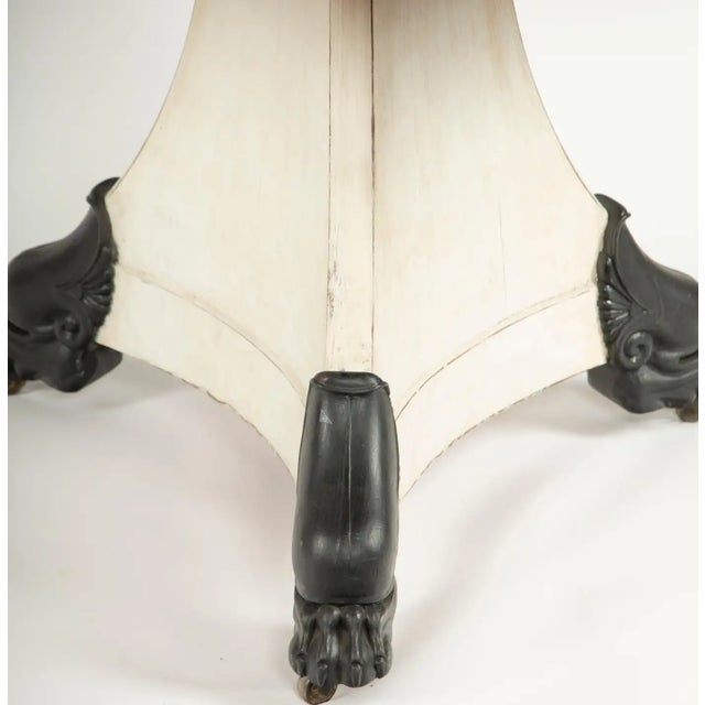 19th Century Center Table with Marble Top and Iron Lion Paw Feet: A striking 19th-century center table featuring a...