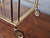 High quality Hollywood Regency bart cart / drinks trolley in gilt brass with 2 glass tiers and a rack for bottles.