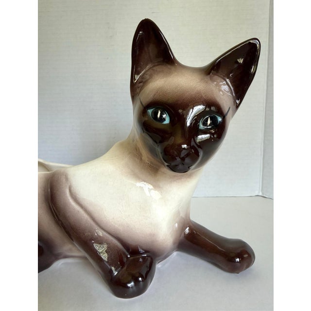 This vintage Siamese cat planter dates to the 1960s and features a wonderfully expressive reclining cat form with striking...