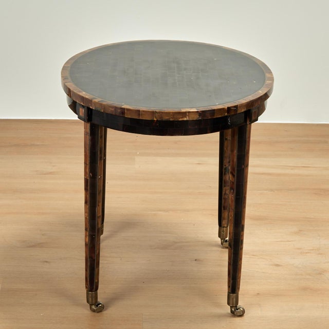 Impressive mid century coffee table having an oval top with a tessellated pen shell field in a steer horn border on a...