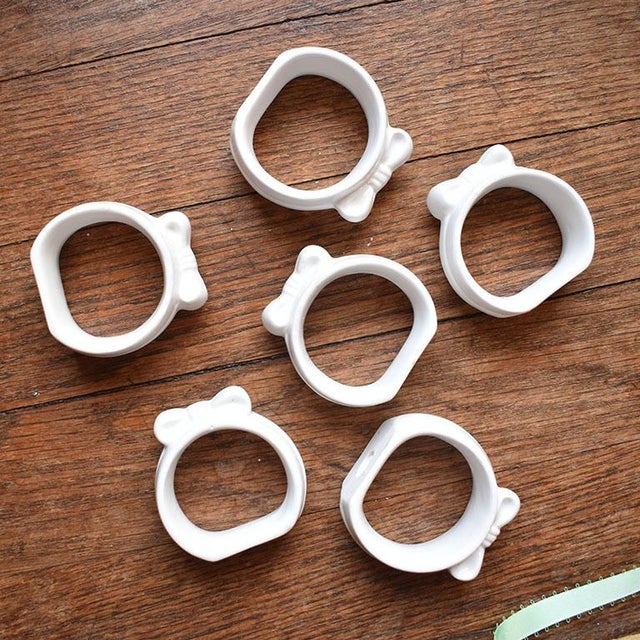 A set of six porcelain ribbon motif napkin rings. This set will be a gorgeous addition to any table setting. Each piece is...