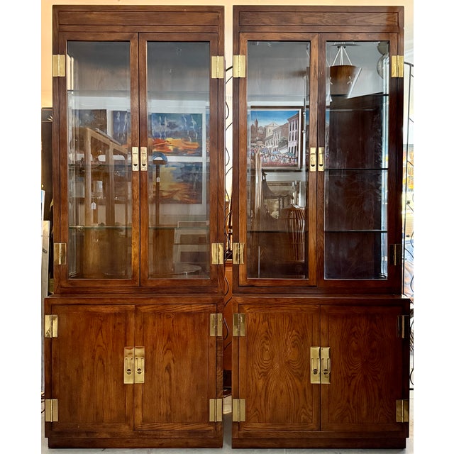 Pair of Henredon Scene One Campaign Style narrow curio China display cabinets. Produced in the 1970s and 1980s, these...