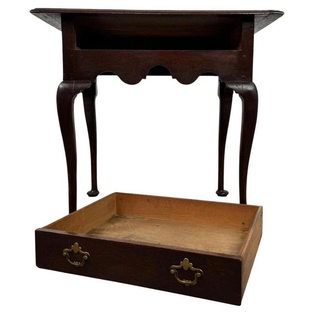 A handsome 18th-century English side table, finely constructed from solid oak and distinguished by its elegant cabriole...