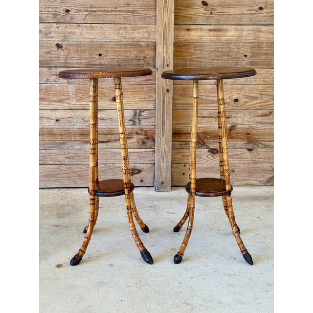 An exceptional pair of Victorian scorched bamboo plant stands featuring richly patterned bamboo, circular oak display...