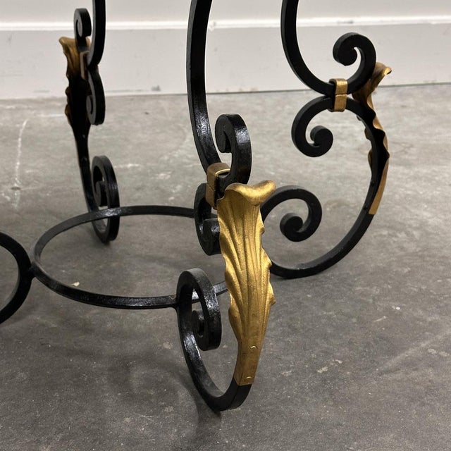 French coffee table from the 1970s, featuring a richly patterned green marble top resting on an ornate wrought iron base...