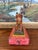 Likely Early 20th-century hand-carved wooden cow figurine mounted on a rectangular painted base. The cow is carved from...