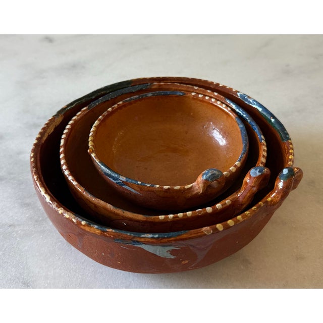 Set of 3 vintage Mexican terra cotta redware nesting bowls with hand painted edges and single handles, handcrafted in...
