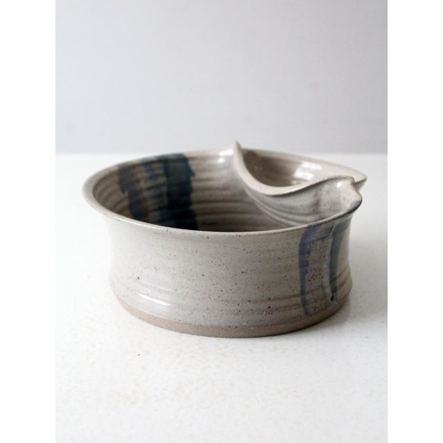 This is a vintage studio pottery bowl. Signed by the artist, the handmade serving bowl features a small pocket bowl on the...