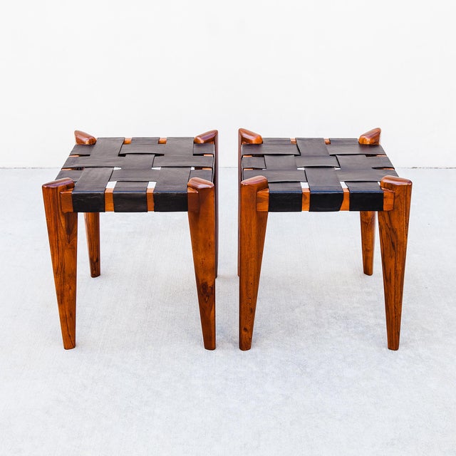 A newly refinished pair of mid-century modern teak and leather stools attributed to Edmond J. Spence, most likely produced...