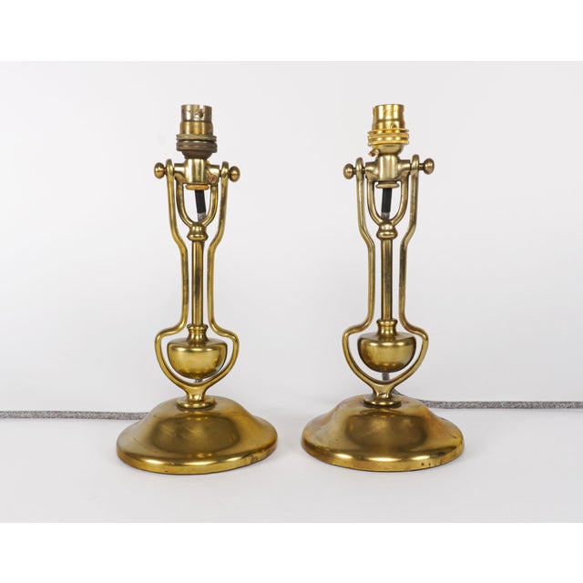 A pair of near-antique brass gimballed lamps suitable for use as wall or table lamps. Designated, and stamped, admiralty...