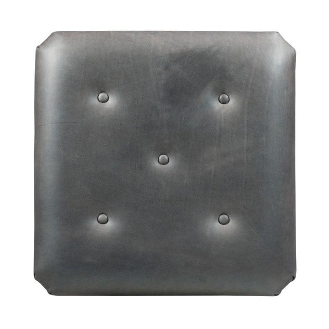 A squared cushion is accented with tufted leather upholstery over molded rails and canted tapering saber legs that...