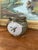 This vintage studio pottery jar features a rounded, bulbous form with a rich olive green glaze and a striking bird...
