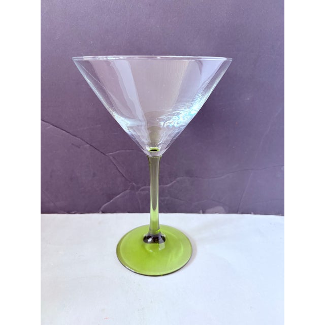 A striking set of six mid-century coupe glasses featuring luminous chartreuse stems and elegant, wide cocktail bowls—an...