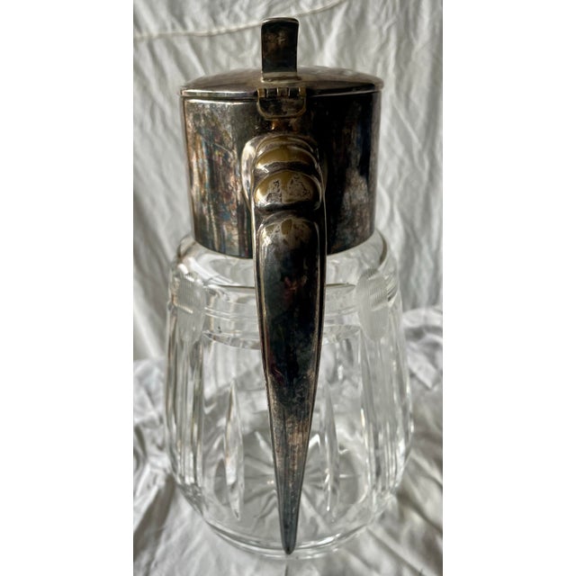This is a great looking cut glass pitcher with a silver plate top and handle. The handle is heavy and solid but the silver...