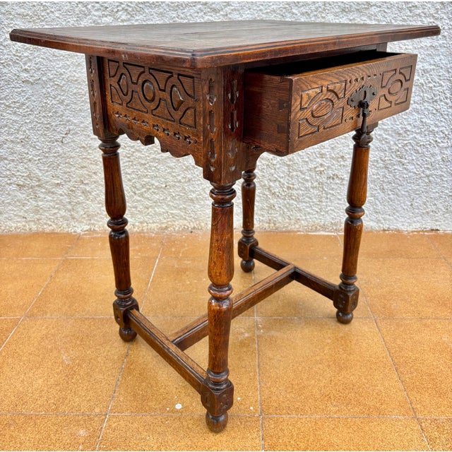 Beautiful Spanish Castilian style side table featuring a single drawer and intricate carved panels, dating from the early...