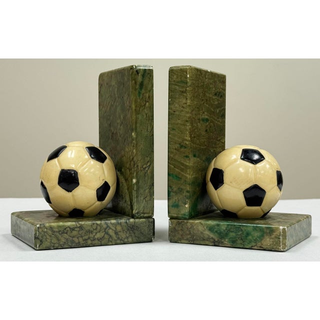 Pair of vintage Italian soccer ball motif bookends. Each bookend features a detailed ivory and black stone soccer ball on...