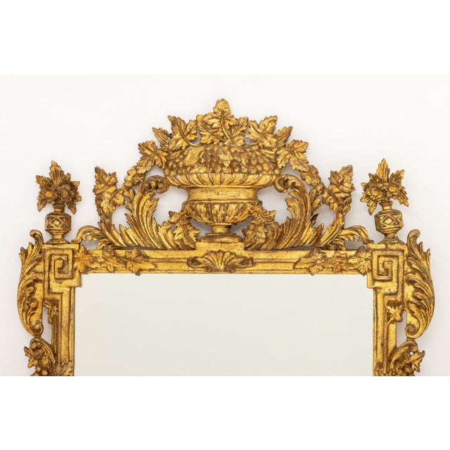 Rococo Style Giltwood Framed Mirror, urn form crest and Greek key details at corners. Mirror plate: 37.25" H x 23.25" W;...