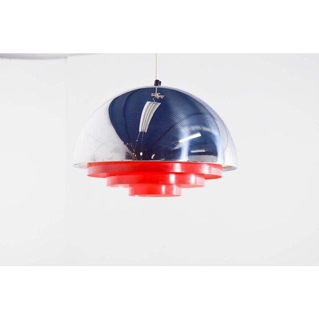 “Milieu” pendant light consists of a half globe made of chromium plated brillant with red metal louvre. with glossy outer...