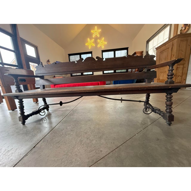 This piece is an Antique Spanish Renaissance Revival Carved Wood Hall Bench, dating from the 1920s. It is crafted from...