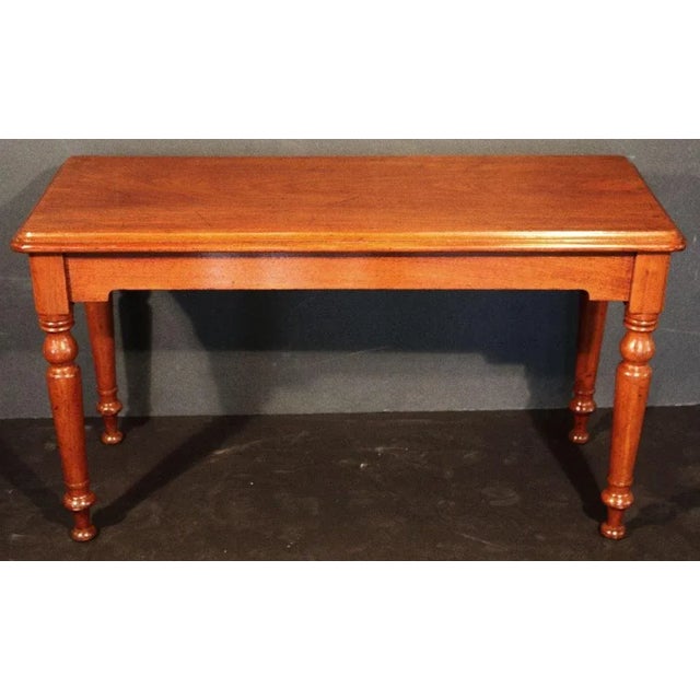 A handsome English console or sofa table of mahogany, from the late 19th century, featuring a rectangular moulded top over...