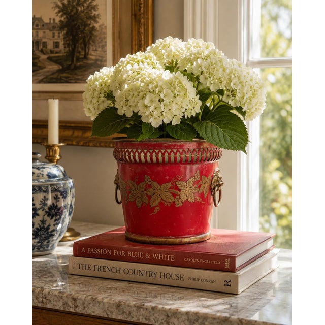 A wonderfully charming early 20th century French tole cachepot finished in a rich cinnabar red with delicate gilt...