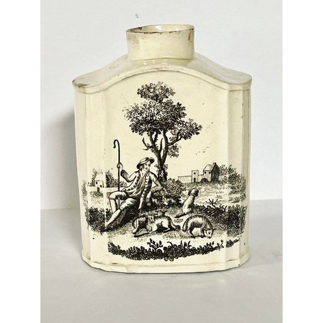 18th-century English George III creamware tea caddy (or tea canister), decorated with black transfer-printed pastoral...