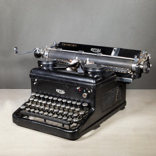 ABOUT An antique Royal Standard typewriter with nickel and black keys with gold letters. The space bar and the carriage...