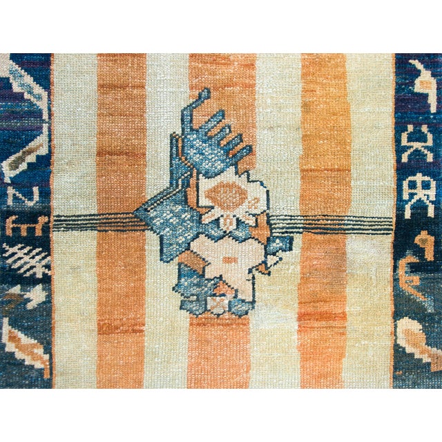 A highly unusual and rare late 19th century Chinese Peking rug with a simple orange and cream striped field with three...