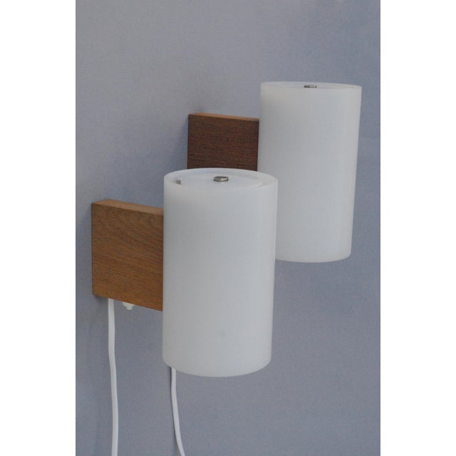An elegant and increasingly rare pair of model 720 wall lights, designed by uno & östen kristiansson and produced by luxus...