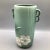 This Weller Pottery Wild rose vase in a green matted finish has double loop handles on each side with the rose stems...