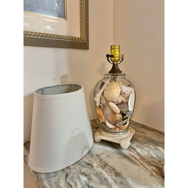 Bring a classic coastal elegance to your space with this beautiful glass shell filled table lamp. Measures 14 inches to...