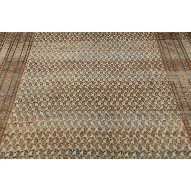 Beautiful antique Malayer hand-knotted wool rug with a beige color field. This Persian rug has brown, blue, and rust...