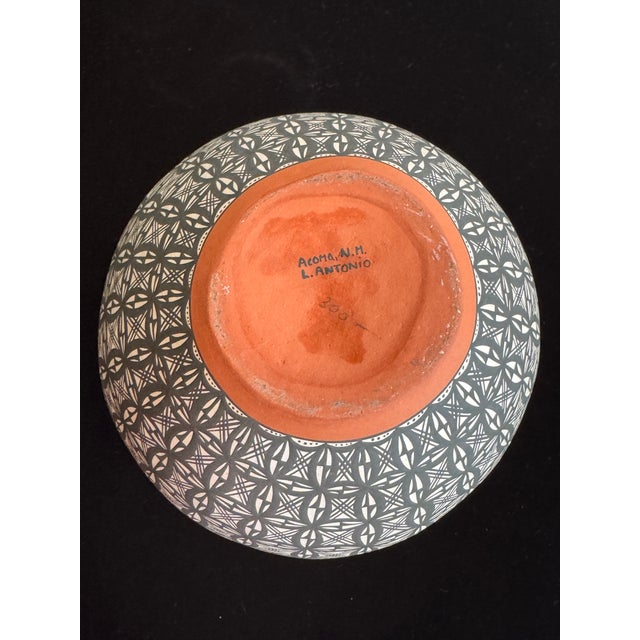 Hand-coiled Acoma Pueblo pottery jar, signed L. Antonio on the base. Measures approximately 7 inches tall by 7 inches...