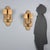 Pair of bronze and sheet metal wall sconces. Two lights supported by curved arms held up by a wooden panel covered in...