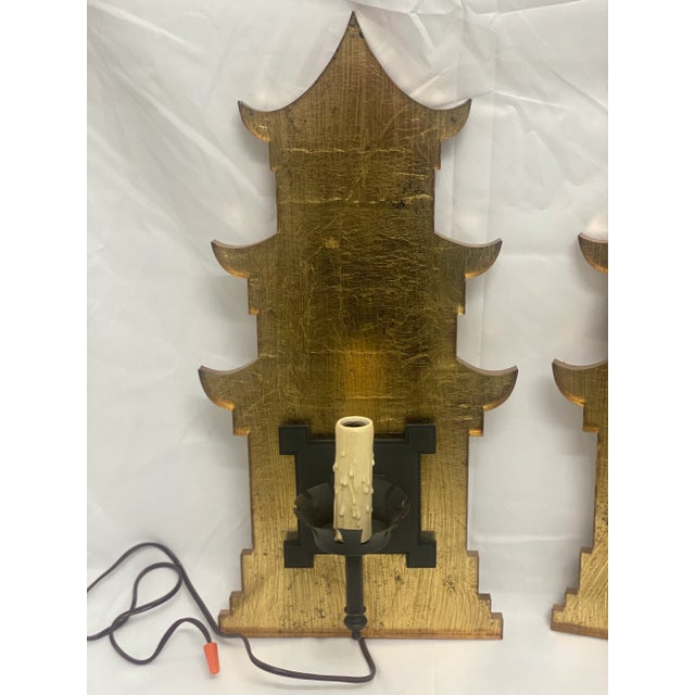 Cut out gold leaf background pagoda sconces. Wired for wall installation. and have a melted candle look for light bulb.