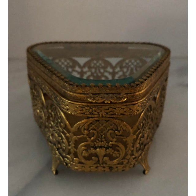 Vintage Hollywood Regency gold filigree hinged footed jewelry box . Bevelled glass top , velvet lined . Measures 5” x 5” x...