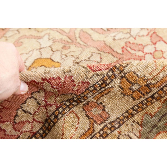 An early 20th century Indian Amritsar antique rug, the caramel field with an allover lattice of flowering vines, curving...