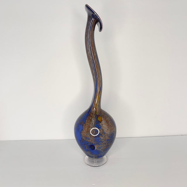A beautiful hand-blown A. Garcia Studio orange glass vase with blue and green decoration. The vase has an elephant trunk-...