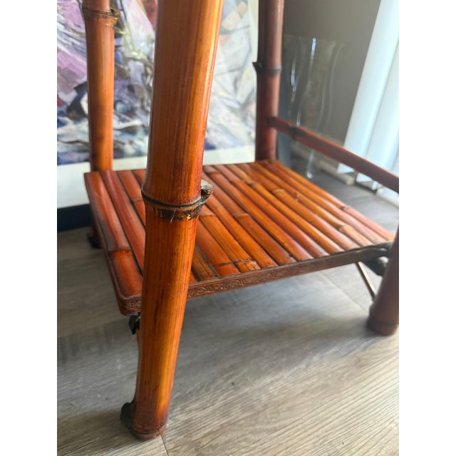 Gorgeous, 20th century tall bamboo ladder style etagere with 6 graduated shelves with embossed copper trim which has...