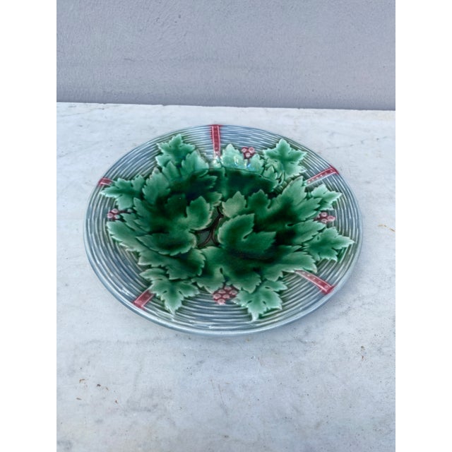 Charming French Majolica plate with grapes & leaves on a grey basket weave background signed Gien, circa 1890.
