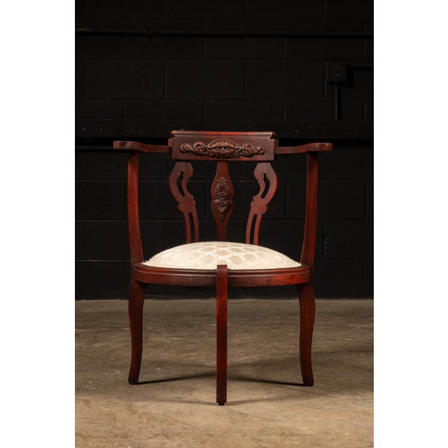 American turn-of-the-century mahogany arm chair with padded and upholstered oval seat panel. This antique piece features...