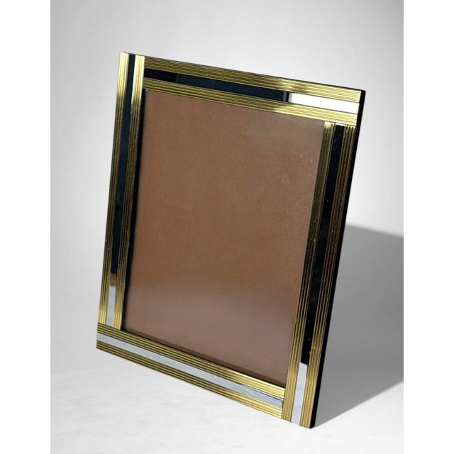 Elegant Italian picture frame crafted in finely worked brass and mirror-polished steel, with a black velvet-covered back....