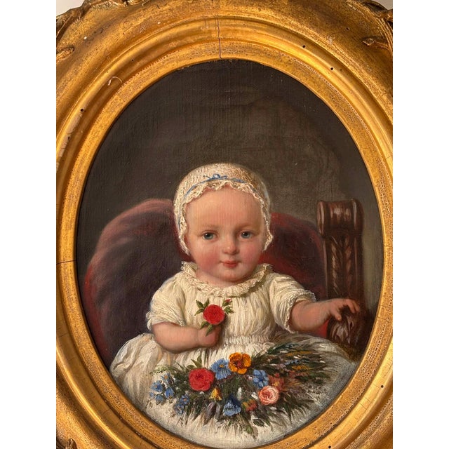 Stunning antique Victorian portrait of a baby painted in oil with a golden oval ornate canvas. The painting features a...