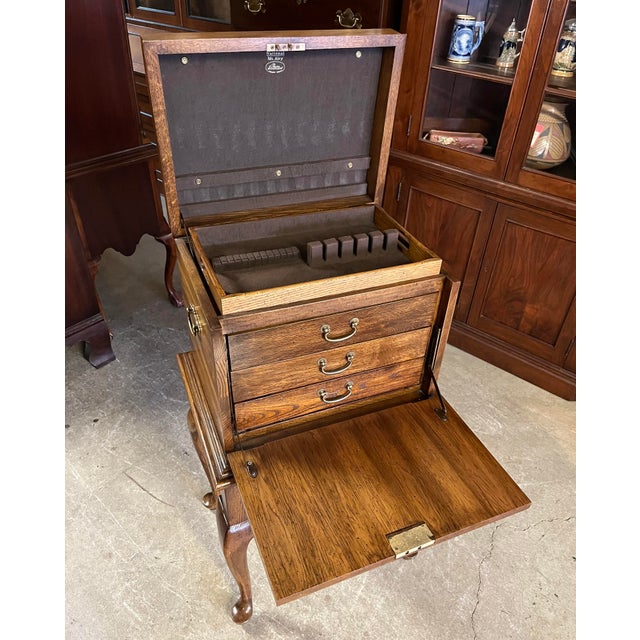 Stunning burn walnut silver chest by National Mt. Airy. The chest lifts open to reveal a removable silverware tray and...